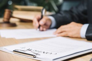 Clipboard with contract papers over wooden desk in courtroom