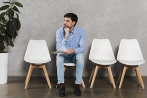 Front view of man holding resume and waiting for his job interview